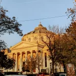 Majestic historic building surrounded by autumn trees in a city centre. Close to some of the best bars in Bucharest.