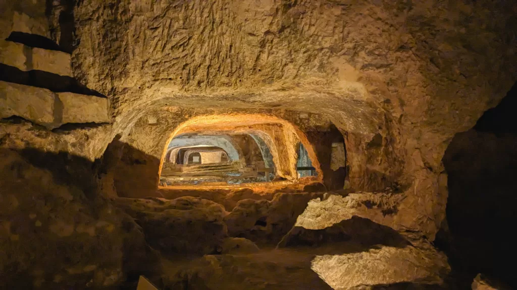 Manmade caves stretch out into the distance, each uplit by an orange glow.