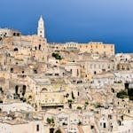 Scenic view of ancient stone architecture in Matera, Apulia, Italy, under a vibrant sky.