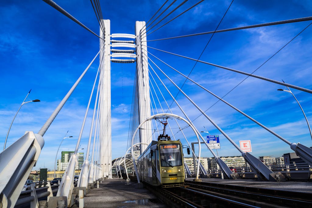 A modern urban bridge featuring an electric train in Bucharest during a clear day. It's easy to get a train to travel from Bucharest airport to the city centre.